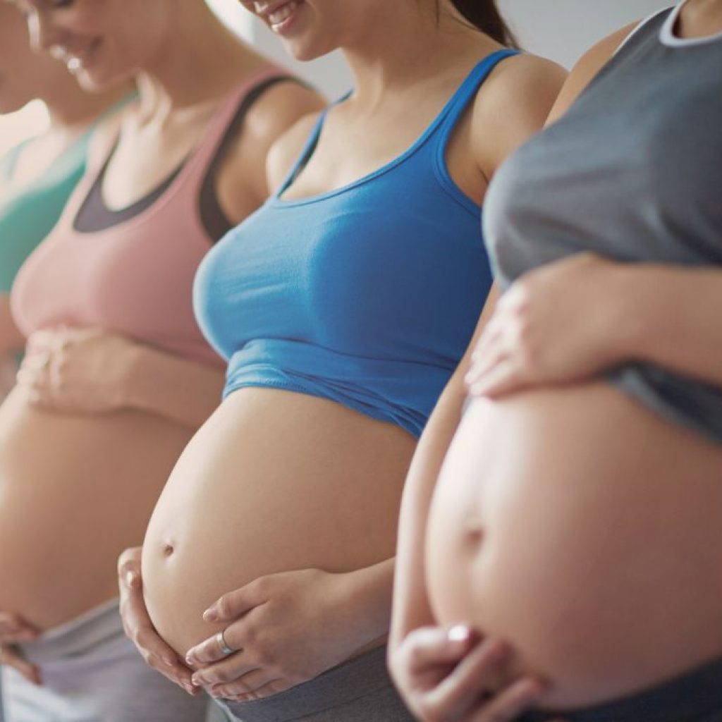 4 pregnant women holding their bellies