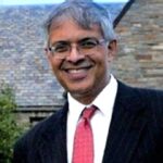 Jay Bhattacharya smiles as he stands in front of a building