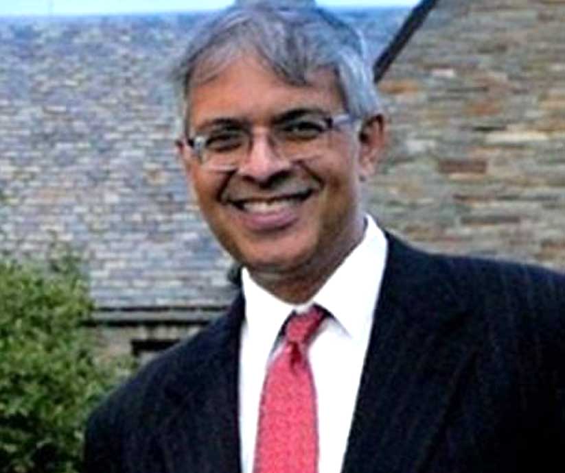 Jay Bhattacharya smiles as he stands in front of a building