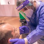 hospital staff administering COVID test to a man