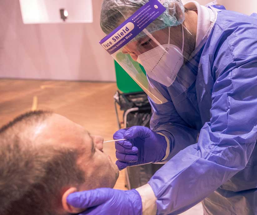 hospital staff administering COVID test to a man