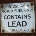 old fashioned sign saying gasoline contains lead