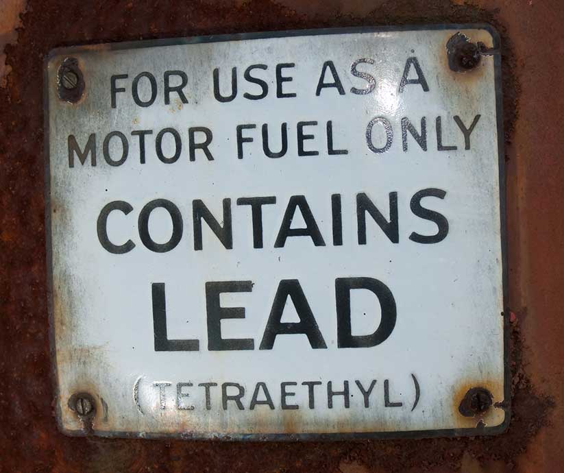 old fashioned sign saying gasoline contains lead