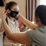 mom putting mask on a pre-teen girl