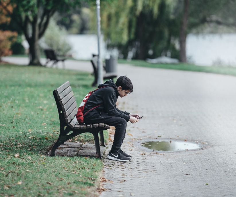 teenager sitting on a bench